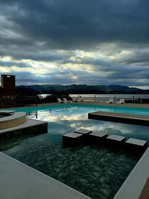 a large swimming pool with a view of the water at Colibrí Del Lago in Villa Parque Siquiman