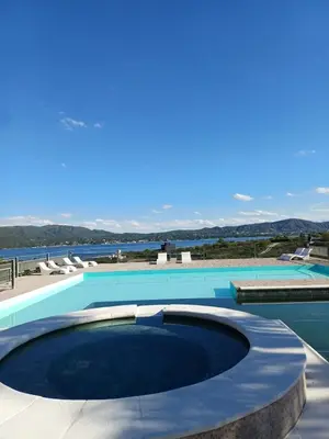 a large swimming pool with chairs and a blue at Colibrí Del Lago in Villa Parque Siquiman