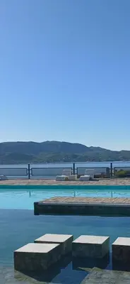 a swimming pool with benches in the water at Colibrí Del Lago in Villa Parque Siquiman