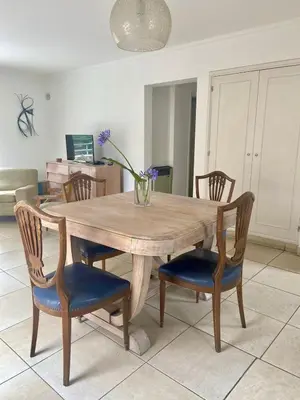 a wooden table with chairs and a vase with flowers on it at Departamento Nuñez in Cordoba