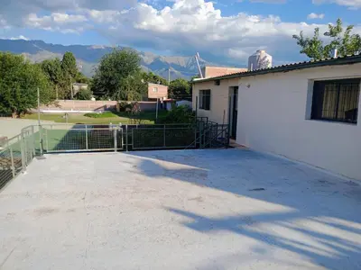 a parking lot next to a building with a tennis court at Departamento Cerca de Todo in Villa de Las Rosas