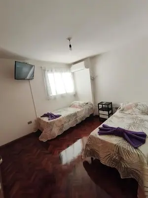 a room with three beds and a flat screen tv at Hermoso Dpto Nva Cordoba in Cordoba