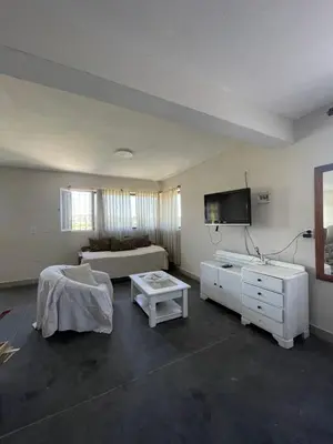 a large living room with a bed and a tv at Loft serenity in Villa Carlos Paz