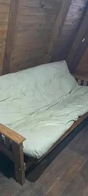 a small bed in a room with a wooden ceiling at El arroyense in Cordoba