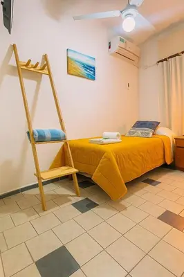a bedroom with a yellow bed and a ladder at Hotel Centro SJ in Villa Carlos Paz