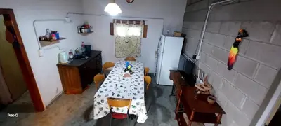 a dining room with a table and a refrigerator at Casitas Serranas en Santa María de Punilla in Santa María