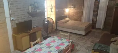 a small bedroom with a bed and a television at Casitas Serranas en Santa María de Punilla in Santa María