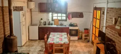 a small kitchen with a table and a refrigerator at Casitas Serranas en Santa María de Punilla in Santa María