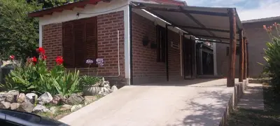 a brick building with an awning next to a driveway at Casitas Serranas en Santa María de Punilla in Santa María