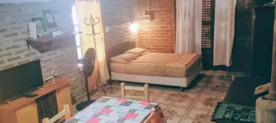 a bedroom with a bed and a desk and a table at Casitas Serranas en Santa María de Punilla in Santa María