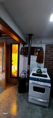 a kitchen with a white stove and a window at Casitas Serranas en Santa María de Punilla in Santa María