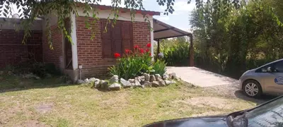 a garden in front of a house with red flowers at Casitas Serranas en Santa María de Punilla in Santa María