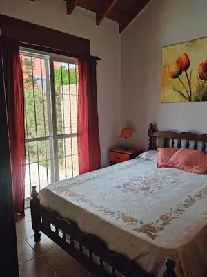 a bedroom with a bed and a large window at No tiene nombre in Mina Clavero