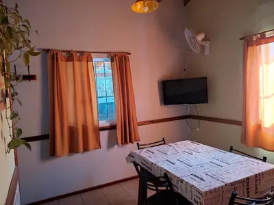 a room with a table and a television and a table and chairs at No tiene nombre in Mina Clavero