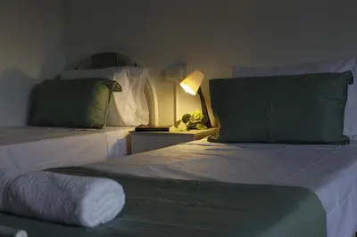 a bedroom with two beds with green pillows and a lamp at Catalina House in Alta Gracia