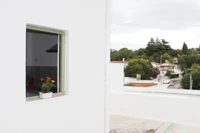 a window in a white house with flowers in it at Catalina House in Alta Gracia