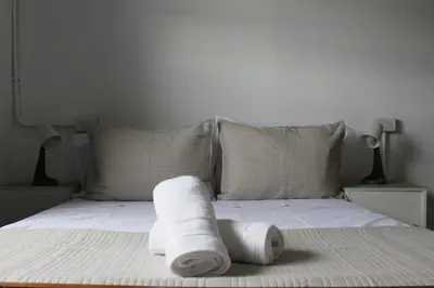 a stack of towels sitting on a bed at Catalina House in Alta Gracia