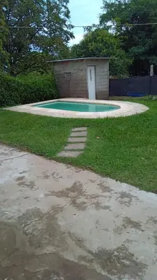 a small swimming pool in a yard with a building at La casita in Villa Santa Cruz del Lago