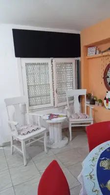 a living room with white chairs and a table at La casita in Villa Santa Cruz del Lago