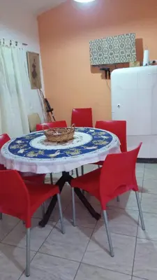 a table with red chairs and a plate on it at La casita in Villa Santa Cruz del Lago