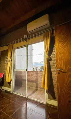 a sliding glass door with yellow curtains in a room at Loft estilo rustico Alta Cba Wifi 100Mb y Escritorio in Cordoba