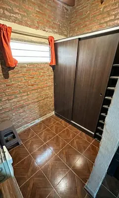 a room with a tiled floor and a door and a brick wall at Loft estilo rustico Alta Cba Wifi 100Mb y Escritorio in Cordoba
