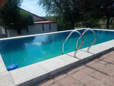 a swimming pool with two metal rails next to it at Bialet Masse in Cuesta Blanca