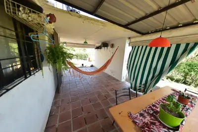 a patio with a table and a hammock in a room at Bialet Masse in Cuesta Blanca