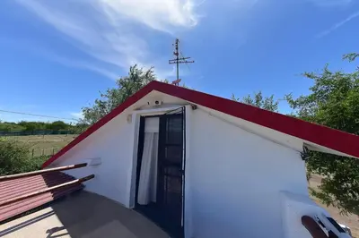 a small white chapel with a red roof and a door at Bialet Masse in Cuesta Blanca