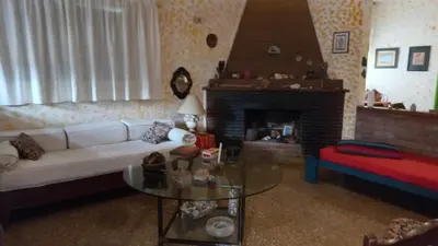 a living room with a white couch and a fireplace at La casa de los titiriteros in Mina Clavero