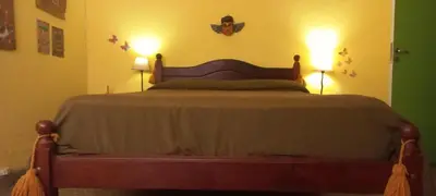a bedroom with a bed with two lights on the wall at La casa de los titiriteros in Mina Clavero