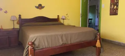 a bedroom with a bed and a yellow wall at La casa de los titiriteros in Mina Clavero