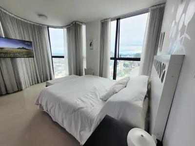 a bedroom with a white bed and a large window at Apartamento Ejecutivo Premium Riviera Tower in Villa Carlos Paz
