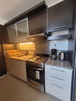 a kitchen with a stove and a counter top at Apartamento Ejecutivo Premium Riviera Tower in Villa Carlos Paz