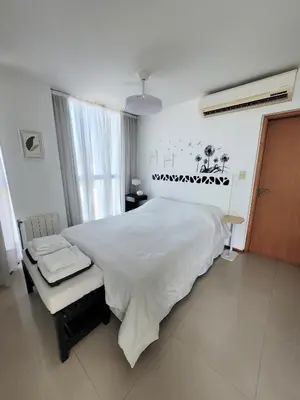 a bedroom with a large white bed and a window at Apartamento Ejecutivo Premium Riviera Tower in Villa Carlos Paz