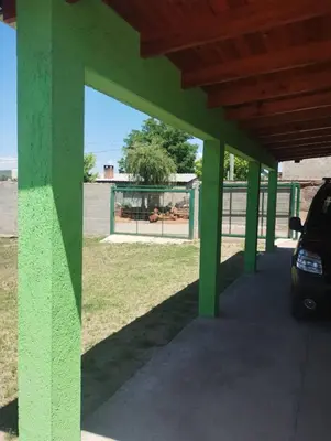 a green building with a car parked under it at Cosquin in Santa María