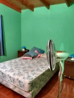 a bedroom with a bed in a room with green walls at Cosquin in Santa María