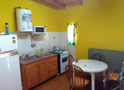 a kitchen with a white refrigerator and a table at Cosquin in Santa María