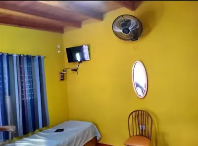 a yellow room with a chair and a mirror at Cosquin in Santa María