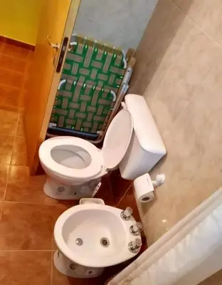 a bathroom with a white toilet and a green field at Cosquin in Santa María