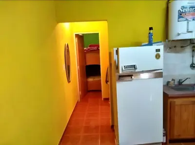 a kitchen with a white refrigerator and a yellow wall at Cosquin in Santa María