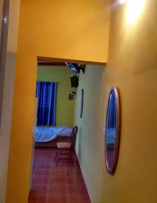 a room with a bed and a chair and a mirror at Cosquin in Santa María