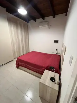 a bedroom with a bed with a red blanket at Remanso in Alta Gracia