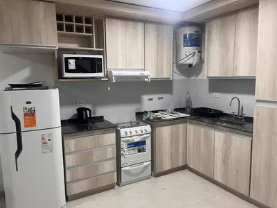 a kitchen with wooden cabinets and a white refrigerator at Remanso in Alta Gracia