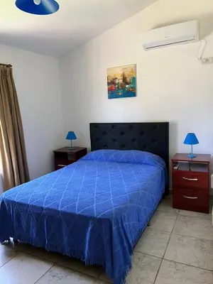 a bedroom with a blue bed and two night stands at Casa Temporal Bialet Massé in Bialet Massé