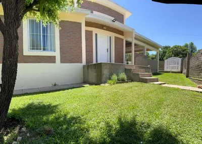 a house with a grass yard in front of it at Casa Temporal Bialet Massé in Bialet Massé