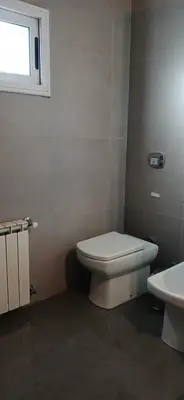a bathroom with a white toilet and a window at Premium Berrotarán in Berrotarán