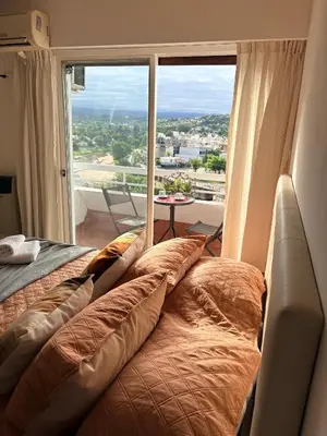 a couch in a room with a large window at El Balcón de Margy Villa Carlos Paz Centro Galeria Acuario Acogedor monoambiente con vista al rio in Villa Carlos Paz