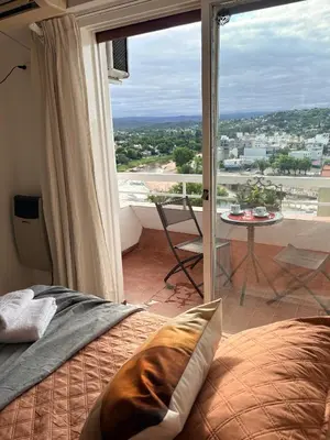a bedroom with a bed and a balcony with a view at El Balcón de Margy Villa Carlos Paz Centro Galeria Acuario Acogedor monoambiente con vista al rio in Villa Carlos Paz