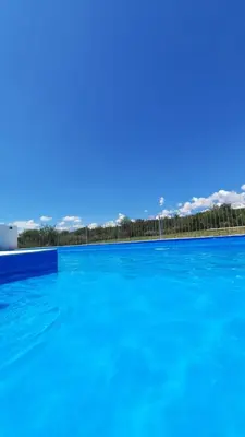 a large swimming pool with blue water at Lucero de Brochero in Villa Cura Brochero